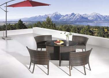 Les meubles de jardin de rotin de 4 Seater placent autour de la table de salle à manger et des chaises en verre
